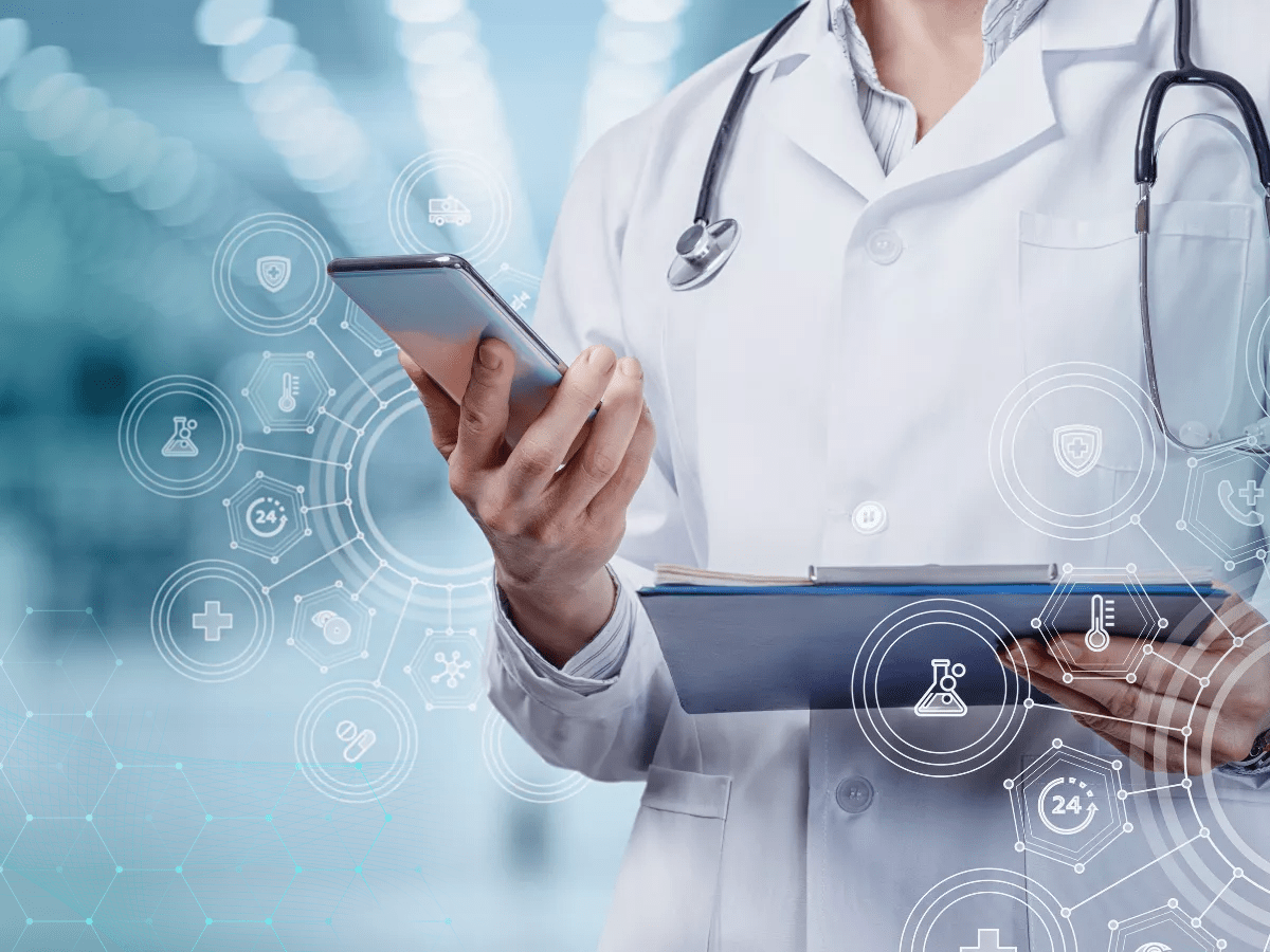 Clinician holding a mobile device while analyzing medical data.